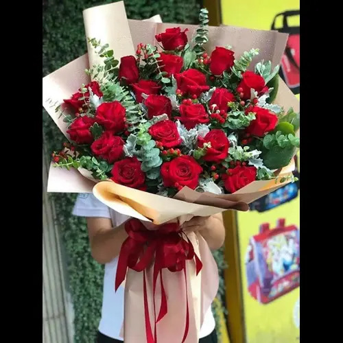 Before: Red rose bouquet held in front of a busy outdoor background